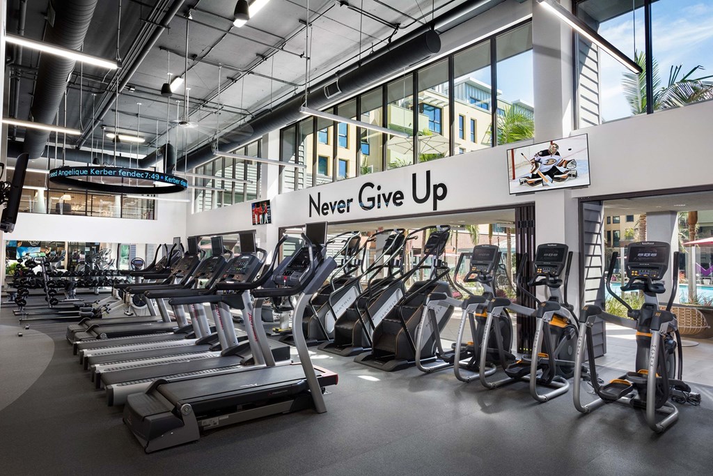 A gym with treadmills and a sign that says "Never Give Up".