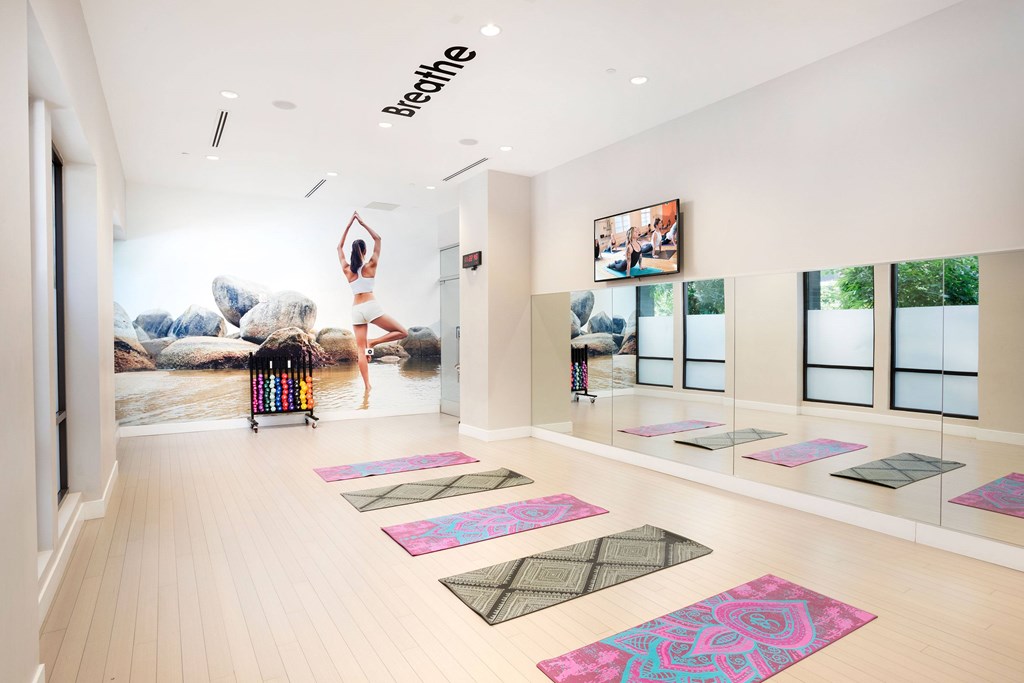 A yoga studio with a woman doing a yoga pose on a poster on the wall.