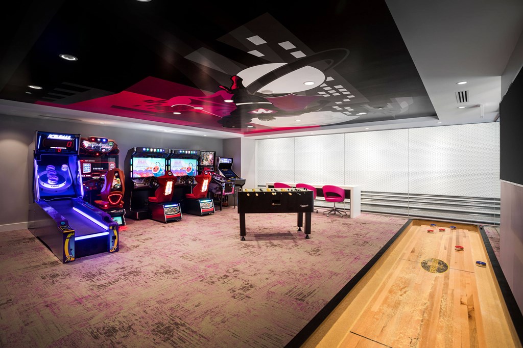 A room with a bowling alley and arcade games.