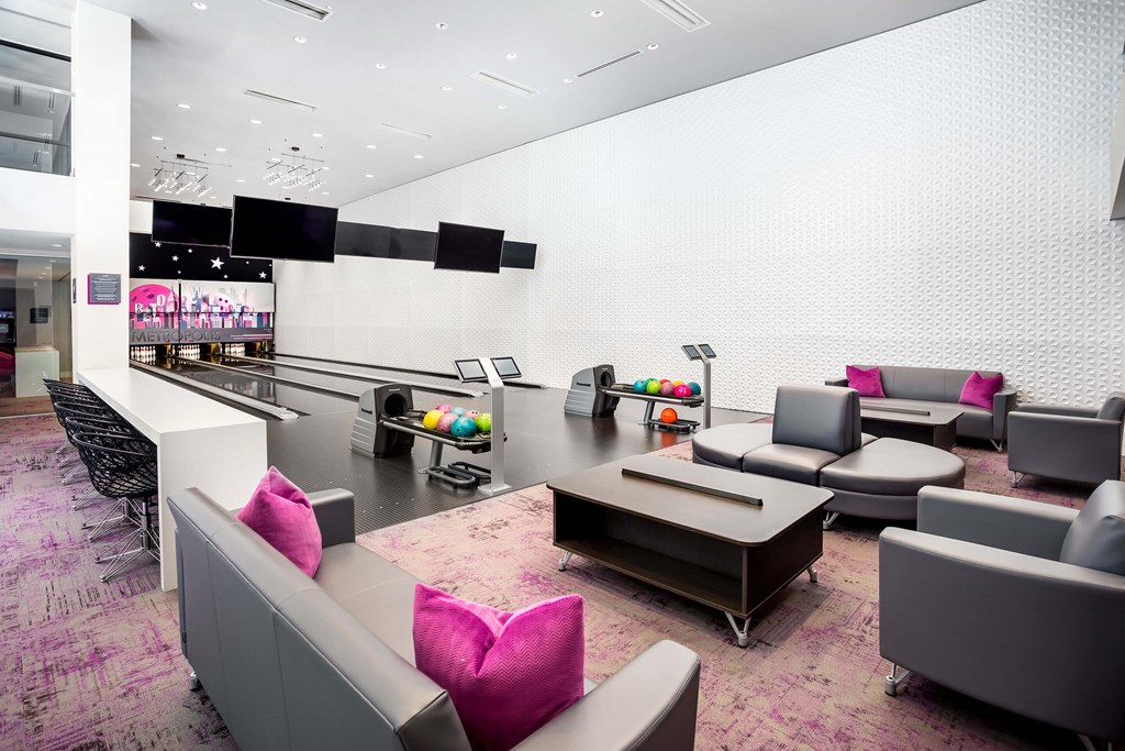 A modern lounge area with grey and pink furniture.