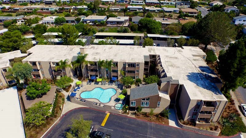 A large building with a pool in front of it.at Pacific Bay Club Apartments, San Diego, CA