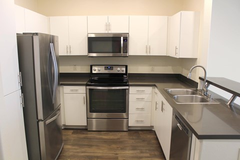 A modern kitchen with stainless steel appliances and white cabinets.