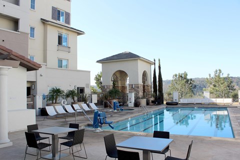 Resort style pool with lounge chairs and cabana at Torrey Gardens Apartments, San Diego, California