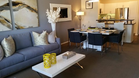 A living room with a blue couch and a white coffee table.