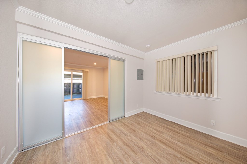 A room with a sliding glass door leading to a balcony.