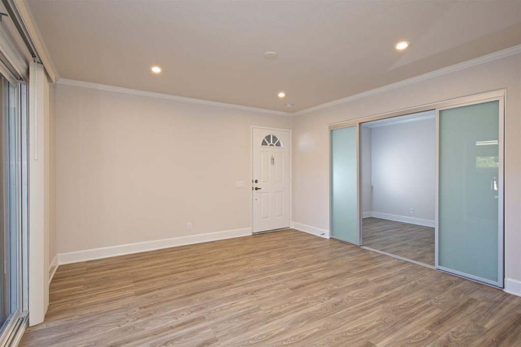 A room with wooden flooring and a sliding glass door.