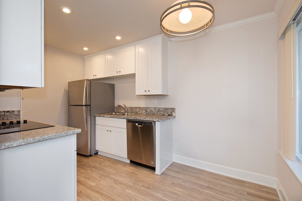 A kitchen with a granite countertop and stainless steel appliances.