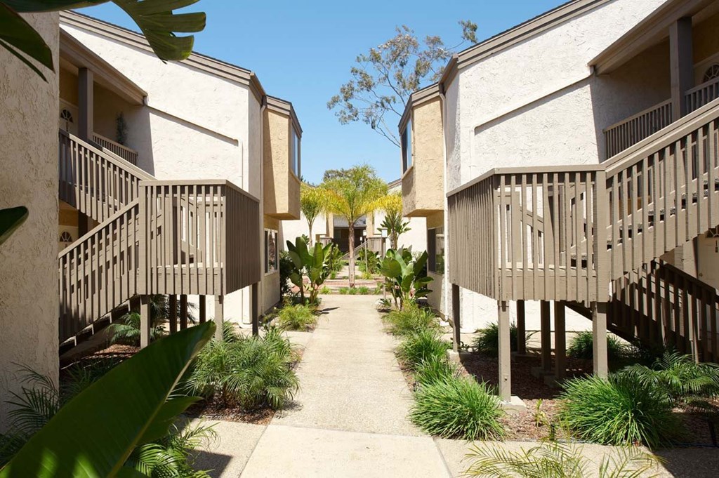 A row of houses with a concrete walkway between them.