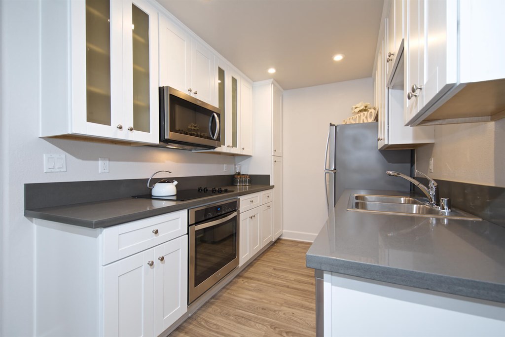 A modern kitchen with white cabinets and stainless steel appliances.