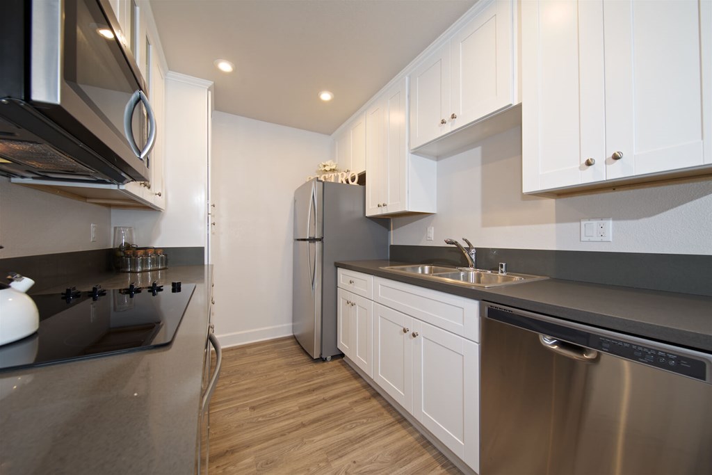 A modern kitchen with stainless steel appliances and white cabinets.