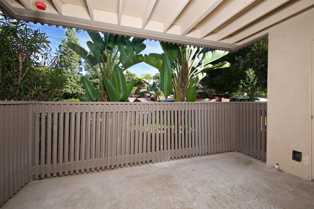 A patio with a wooden fence and a red light on the ceiling.