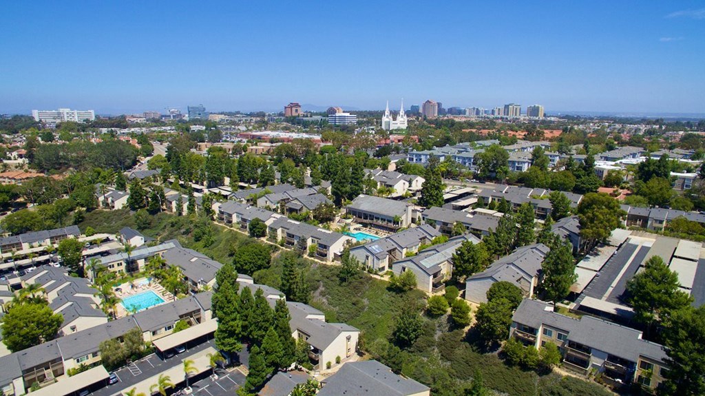 A bird's eye view of a residential area with houses and a pool.