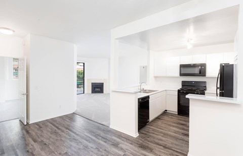 A modern kitchen with a black stove top oven and microwave.