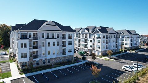 A large white building with a parking lot in front.