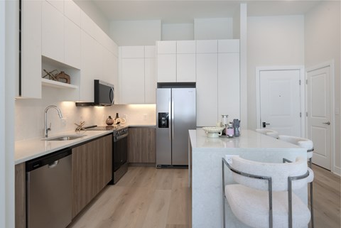 A modern kitchen with a white countertop and wooden cabinets.