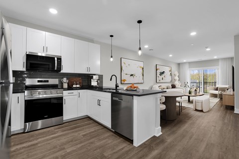A modern kitchen with white cabinets and stainless steel appliances.