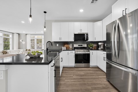 A modern kitchen with stainless steel appliances and white cabinets.