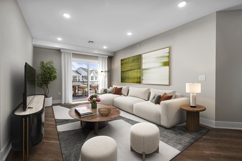 A modern living room with a large window, a white sofa, and a wooden coffee table.