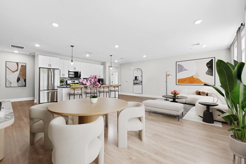 A modern dining room with a wooden table and white chairs.
