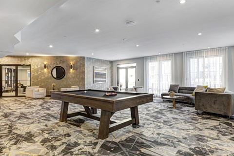 A room with a pool table and a couch.