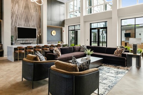 A modern living room with a dark brown sofa and a wooden floor.