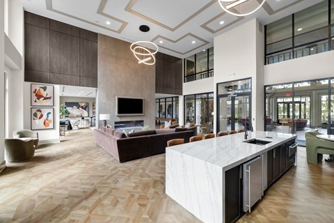 A modern living room with a kitchen area in the background.