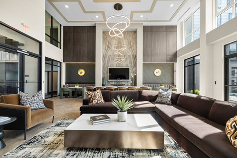 A modern living room with a large sofa, a coffee table, and a chandelier.