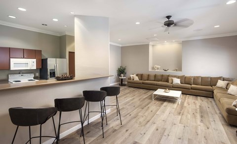 A modern living room with a kitchen area in the background.