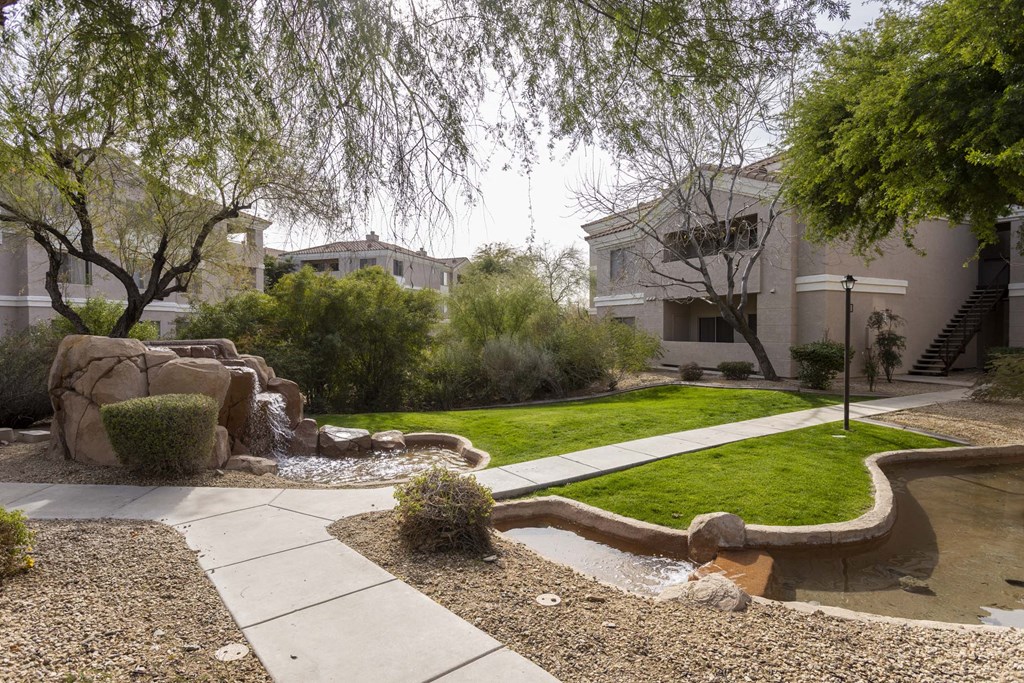 A garden with a water feature and a pathway.at Vintage at Scottsdale, SCOTTSDALE, AZ 85260