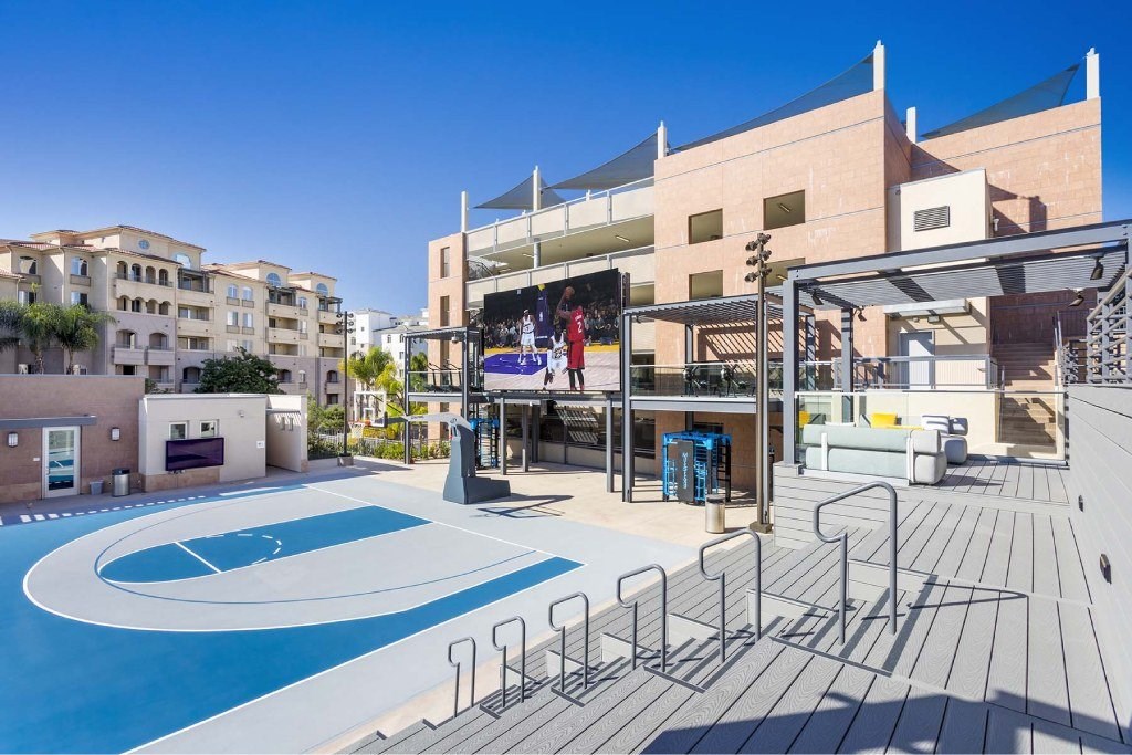 A pool area with a blue pool and a stage with a red backdrop.