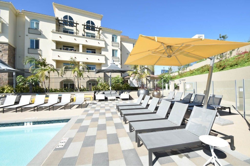 A sunny day at the pool with lounge chairs and umbrellas.