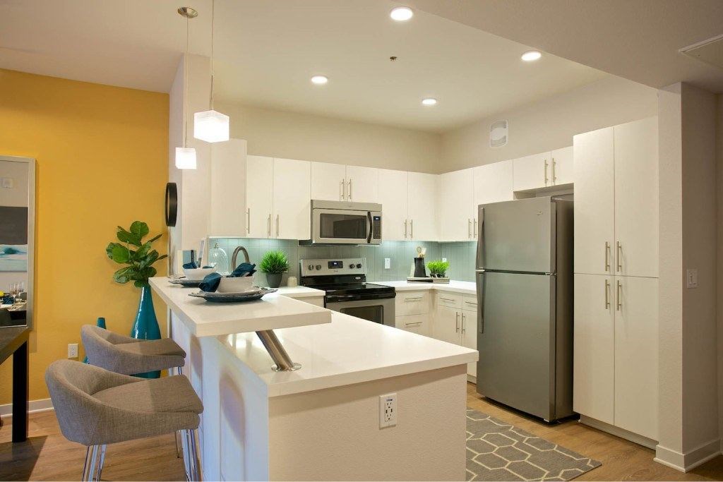 A modern kitchen with a white island and a refrigerator.