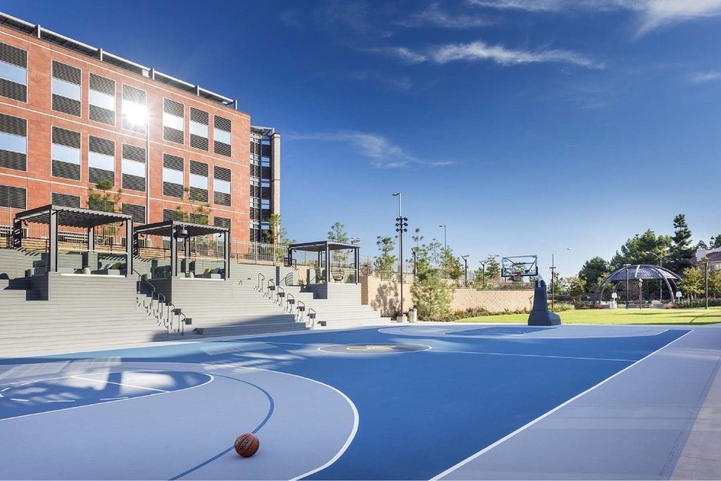 A basketball court with a ball on it and a building in the background.