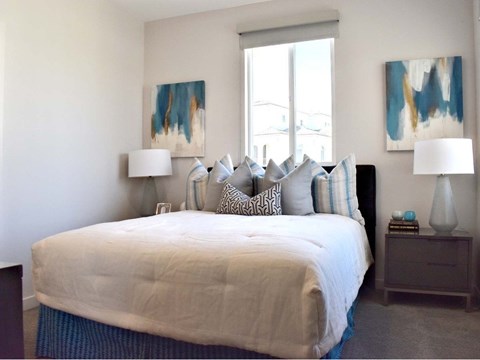 Bedroom with abstract art and upholstered bench at 360 Luxury Apartments, San Diego, California