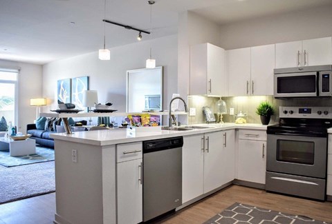 A modern kitchen with white cabinets and stainless steel appliances.
