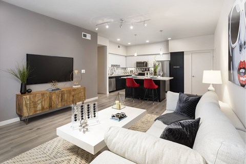 A modern living room with a white sofa and a wooden sideboard.