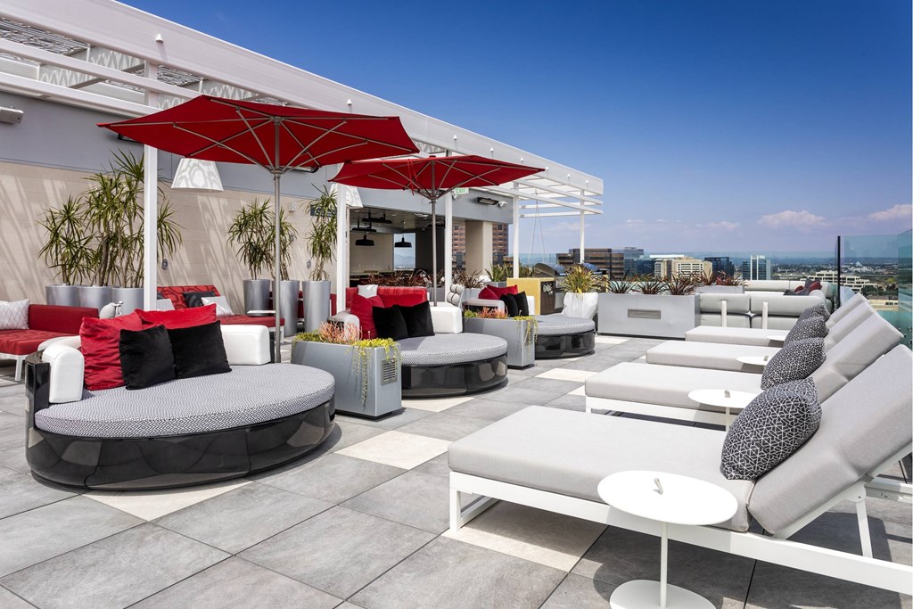 A patio with white furniture and red umbrellas. at LUX by Garden*, San Diego