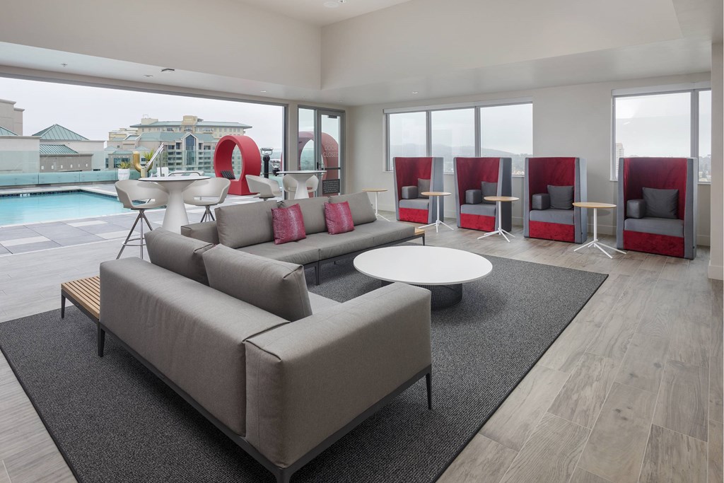 A modern living room with a pool outside the window. at LUX by Garden*, California, 92122
