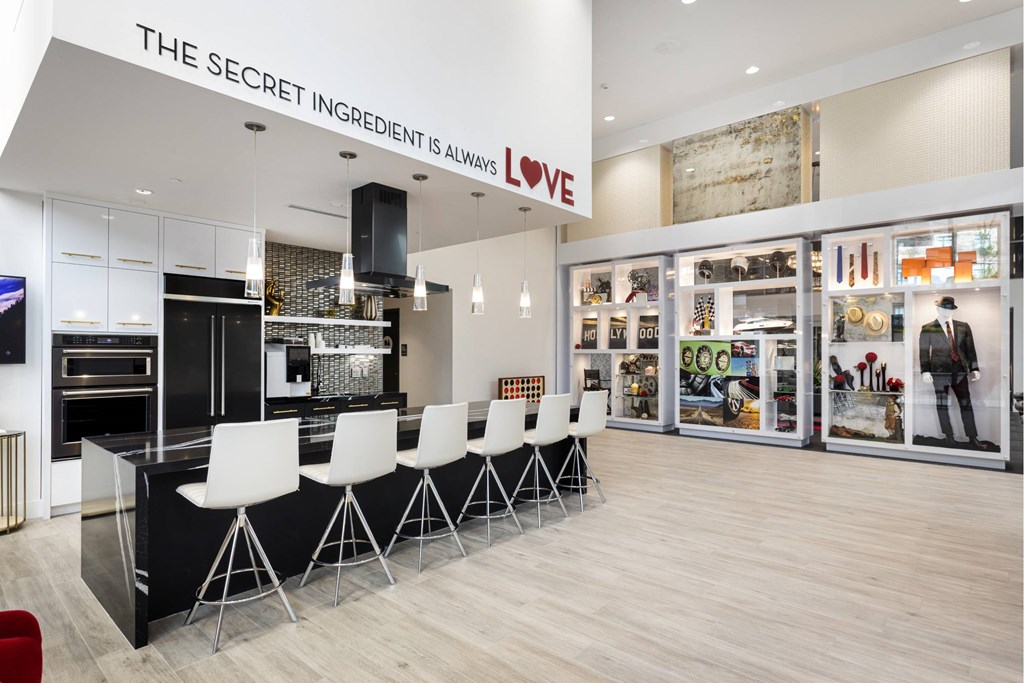 A modern kitchen with a black countertop and white chairs. at LUX by Garden*, California, 92122