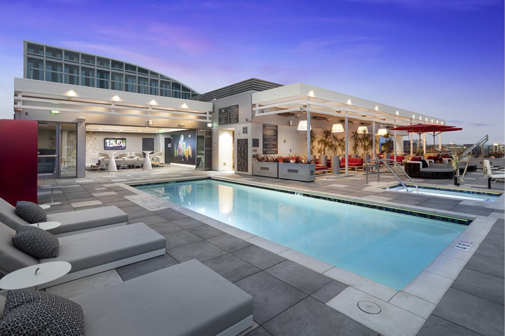 A modern outdoor pool area with a lounge and a building in the background. at LUX by Garden*, San Diego