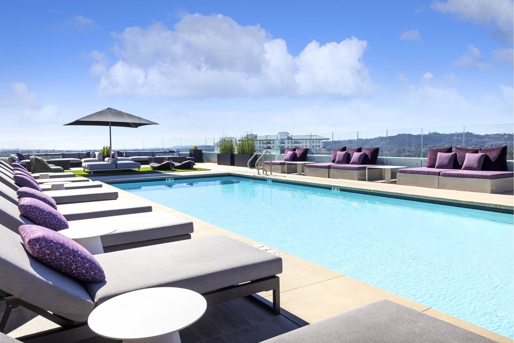 A poolside area with sun loungers and a view of the city. at LUX by Garden*, California, 92122