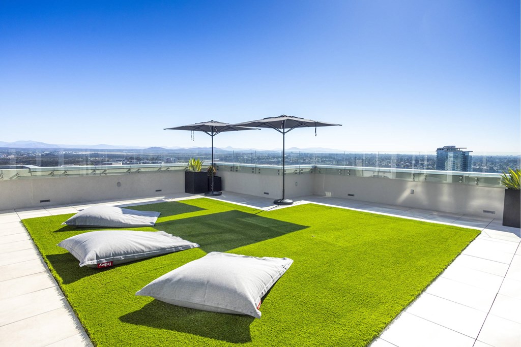 A patio with a white umbrella and a green lawn. at LUX by Garden*, San Diego, CA, 92122