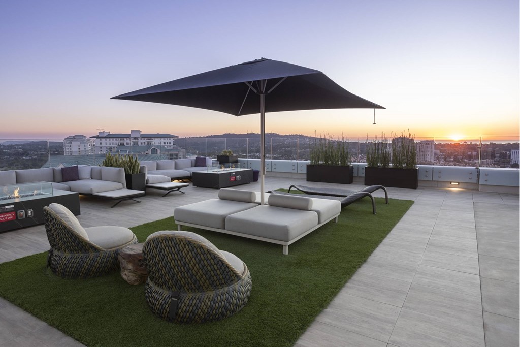 A patio with a black umbrella and white furniture. at LUX by Garden*, California, 92122