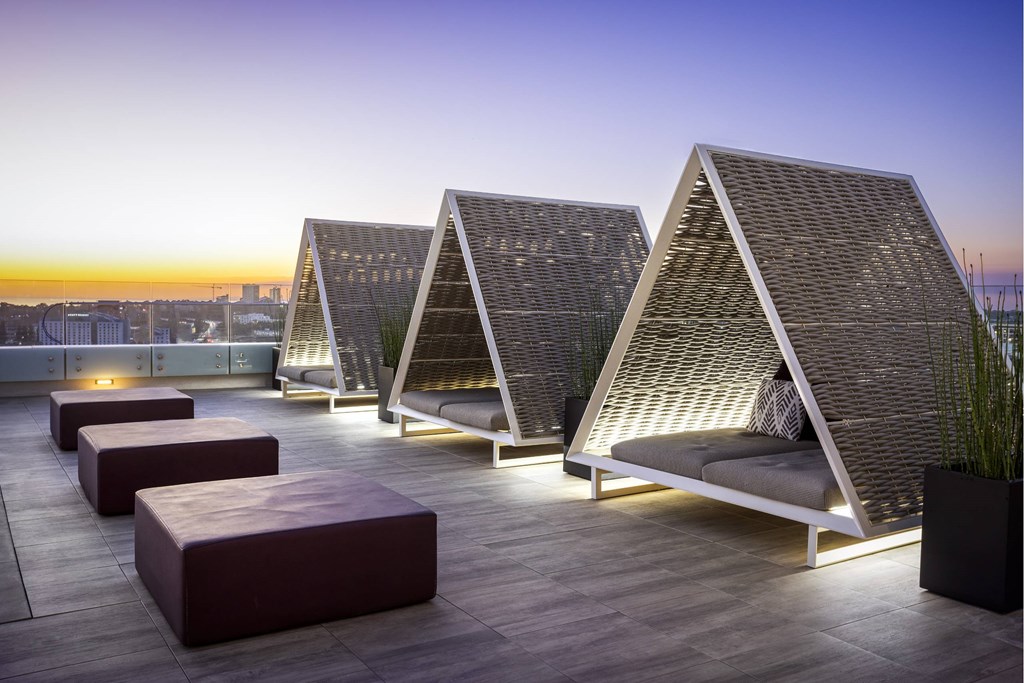 A series of outdoor seating areas with triangular roofs and rectangular tables. at LUX by Garden*, San Diego, CA, 92122