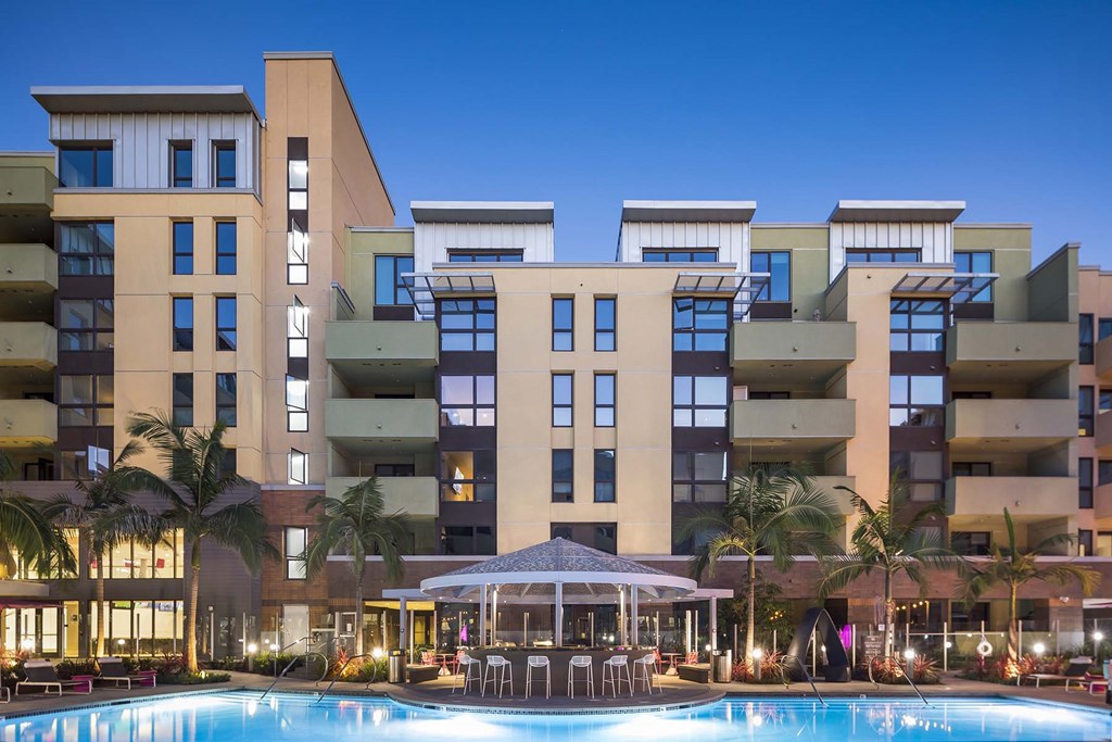 A large building with a pool in front of it.