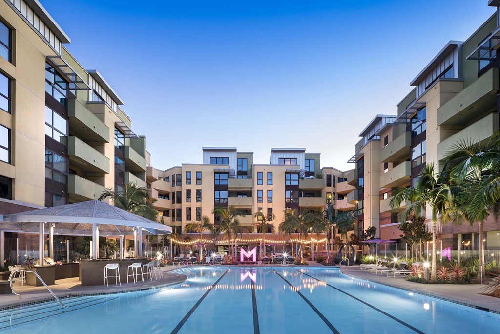 A swimming pool in front of apartment buildings.