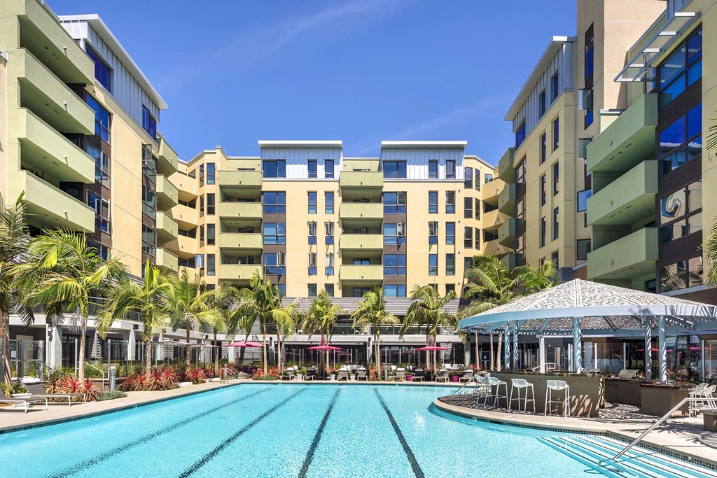 A large swimming pool in front of apartment buildings.
