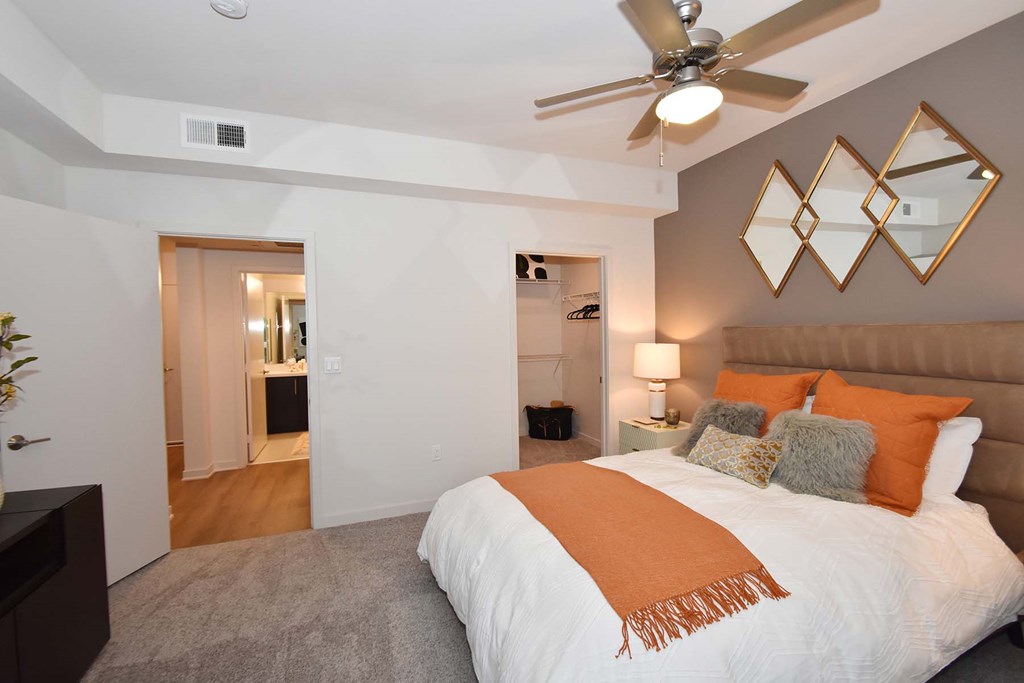A bedroom with a large bed and a ceiling fan.