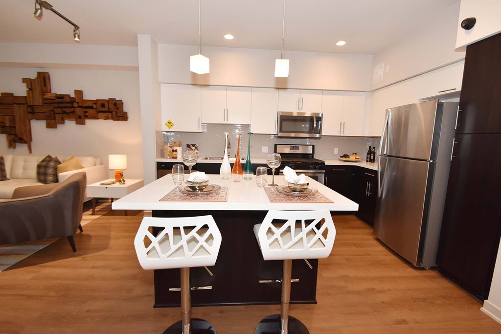 A modern kitchen with a white table and chairs.