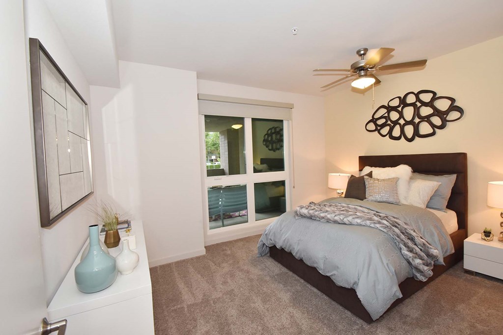 A bedroom with a large bed and a ceiling fan.